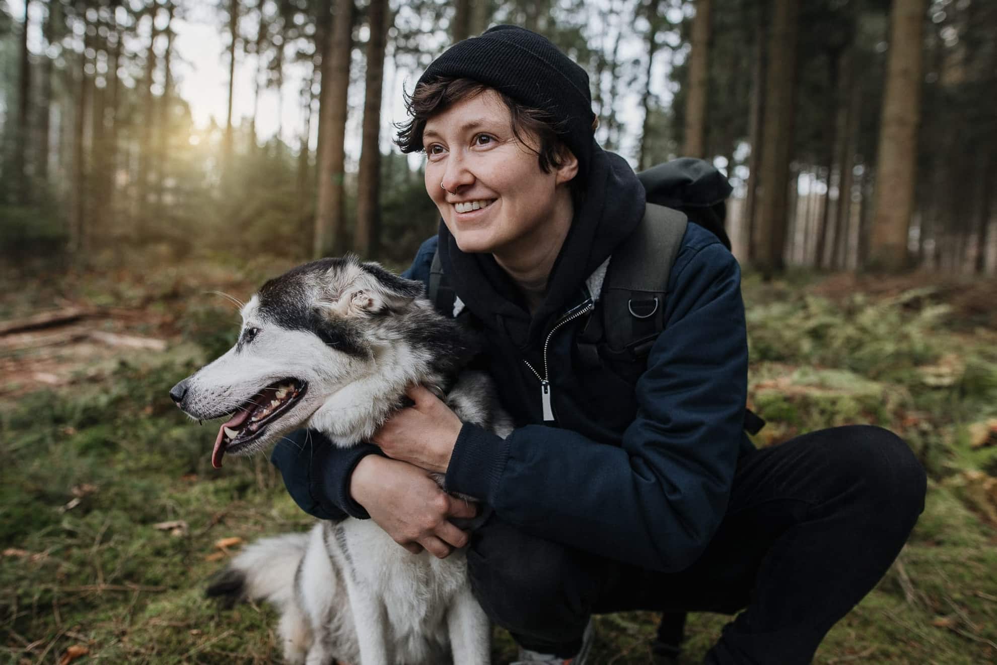 Portrait eines Hundes mit jungem Mann im Wald