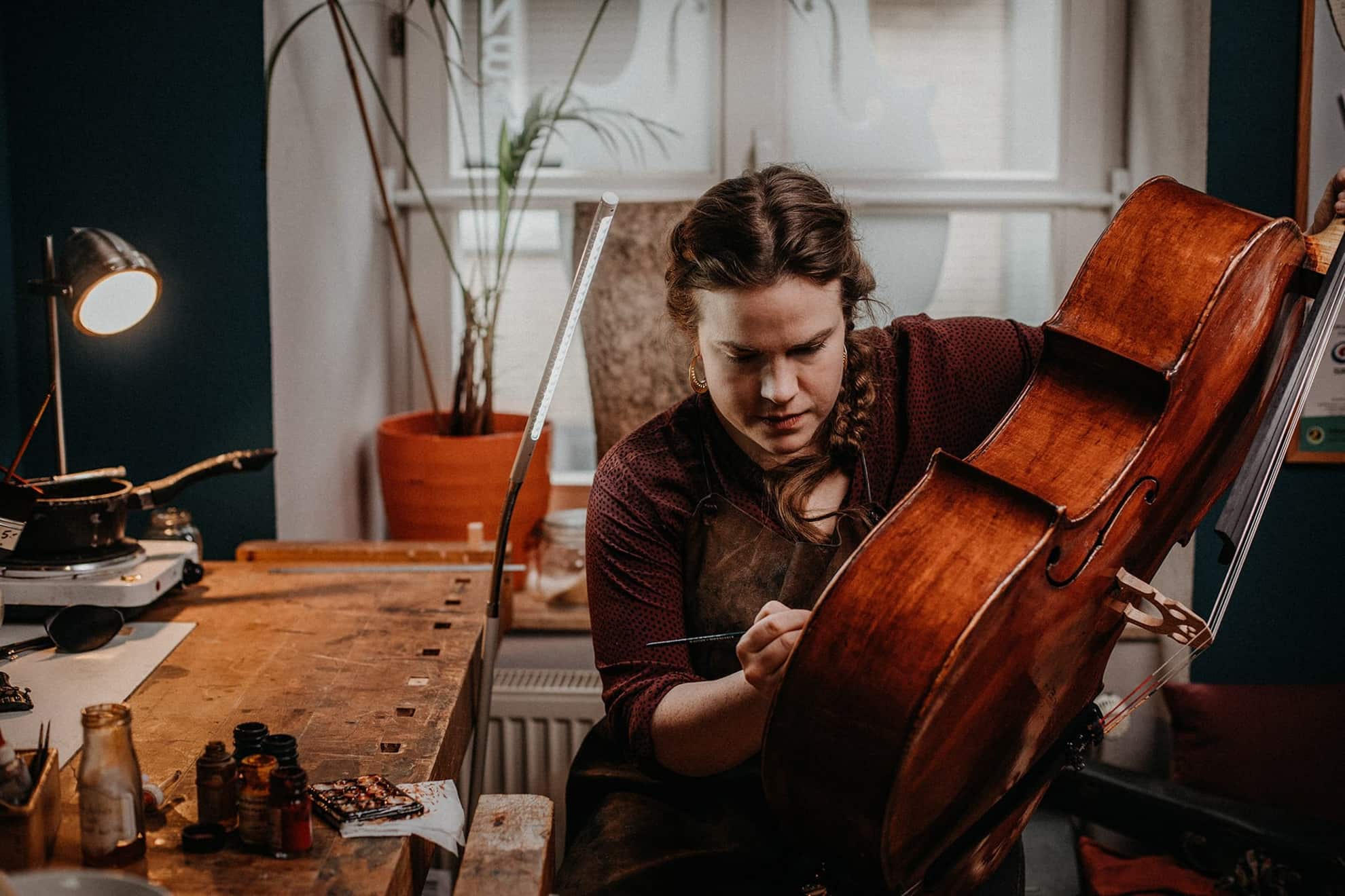 Geigenbauerin bei der Arbeit in ihrer Werkstatt